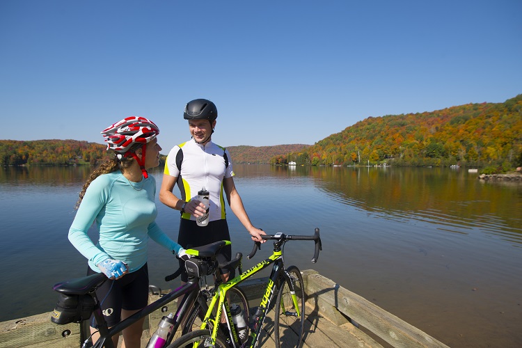Couple en vélo de route prenant une pause devant un lac